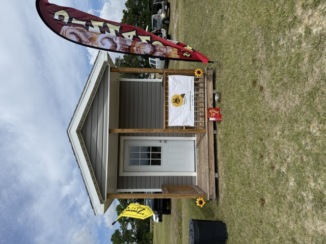 B Blessed Bakery cabin at Chubby's Farm with sunflower sign and cinnamon roll flag