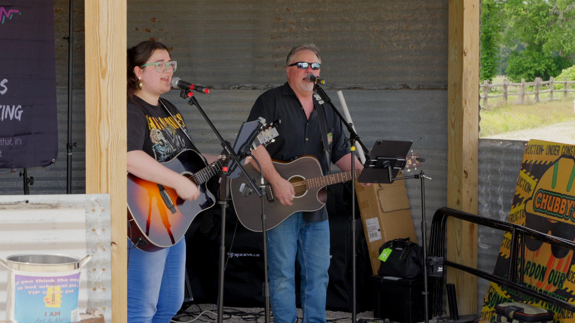 Acoustic duo performing under the corrugated metal stage roof at Chubby's