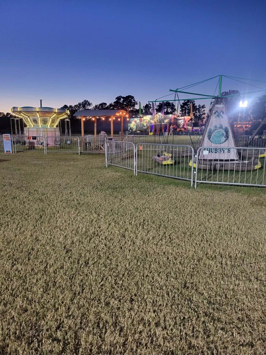 Lit-up swing carousel and Chubby's swing tower glowing at dusk